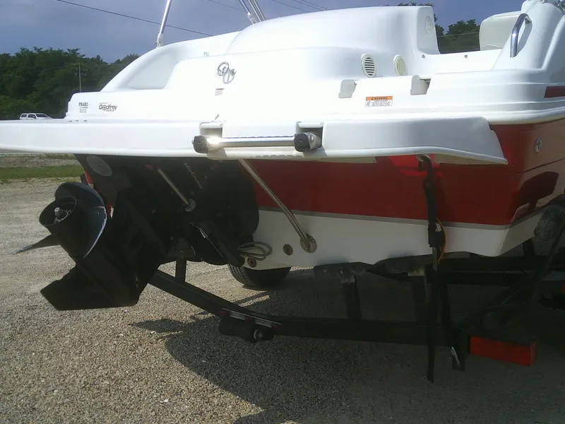 Slide: The Image of 2011 Hurricane SunDeck Sport 188 IO boat rear view, showcasing outboard motor and trailer. - 19