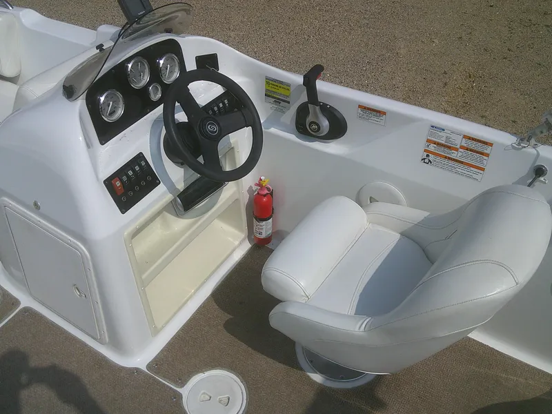 Slide: The Image of 2011 Hurricane SunDeck Sport 188 IO boat interior with steering wheel and captain's chair. - 8