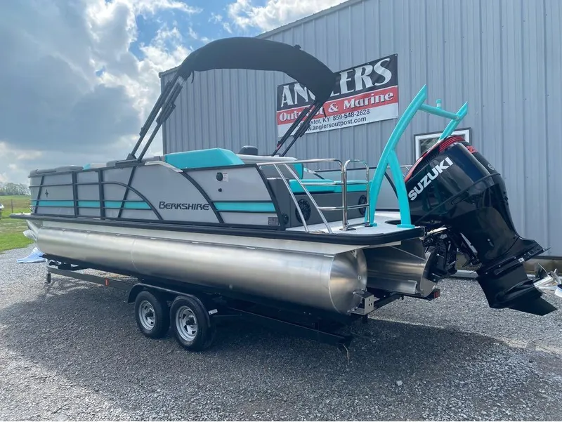 Slide: The Image of 2025 Berkshire 25 SB2 STS pontoon boat with Suzuki engine on trailer, outdoors. - 13