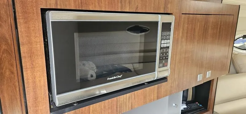 Slide: The Image of Microwave in 2015 Monterey 295 Sport Yacht interior, wooden cabinetry, modern design. - 11