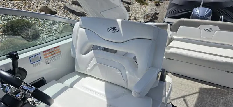 Slide: The Image of 2015 Monterey 295 Sport Yacht interior with white seating and steering wheel. - 18
