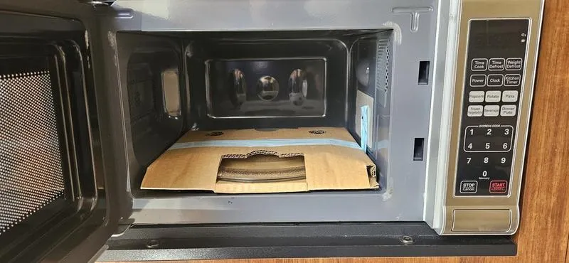 Slide: The Image of Open microwave with cardboard box inside, onboard a 2015 Monterey 295 Sport Yacht. - 8