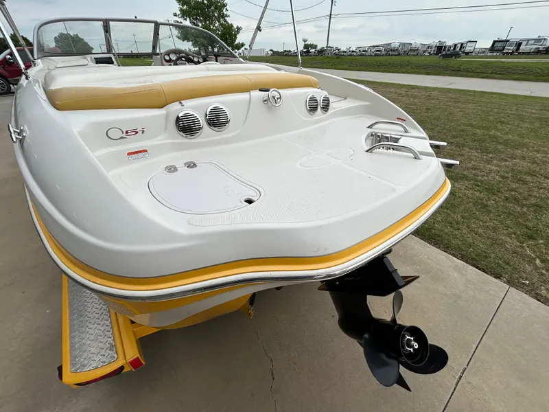 Slide: The Image of 2010 Tahoe Q5SI boat with yellow trim, rear view showing deck and propeller. - 13