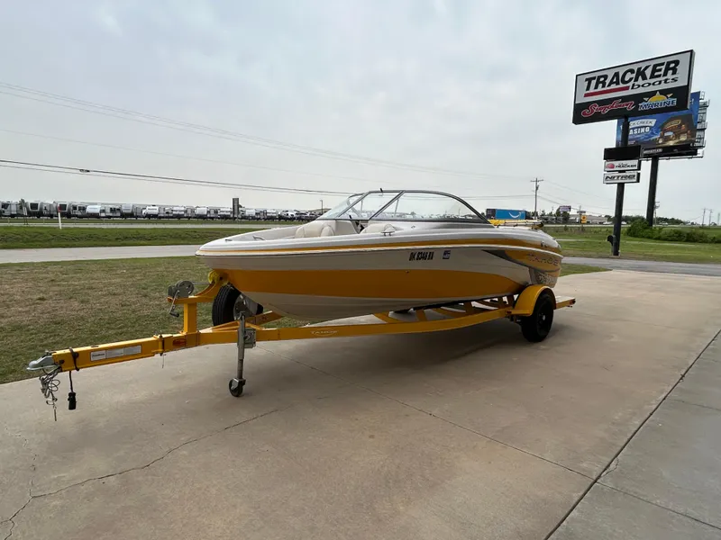 Slide: The Image of 2010 Tahoe Q5SI boat on trailer near Tracker Boats sign. - 3