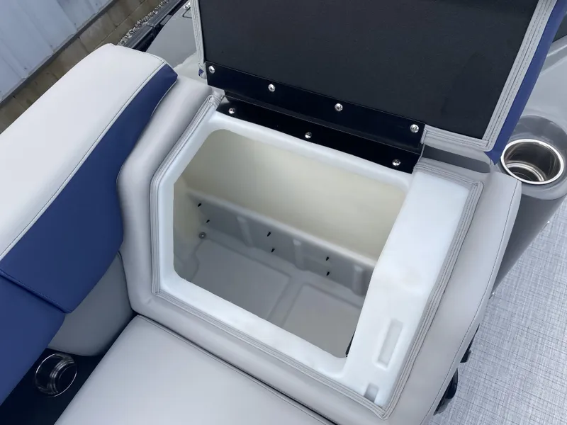 Slide: The Image of Open storage compartment on 2025 Berkshire 23E STS boat with cushioned seating. - 1