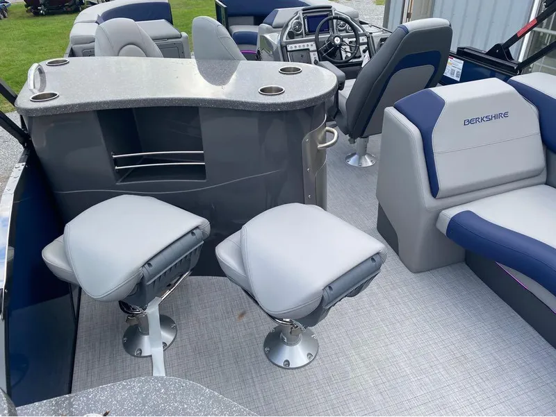 Slide: The Image of 2025 Berkshire 23E STS boat interior with modern seating and steering console. - 11