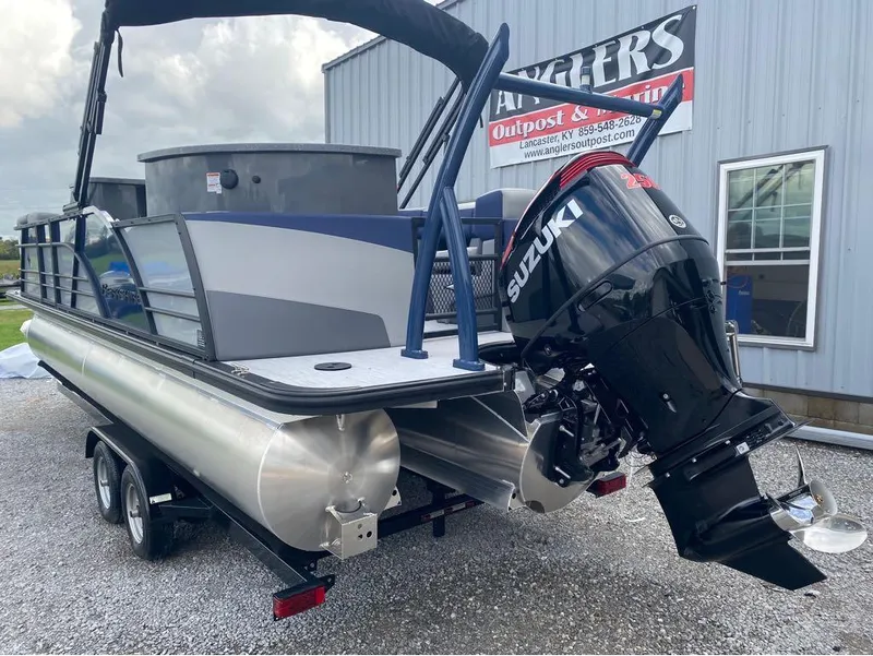 Slide: The Image of 2025 Berkshire 23E STS pontoon boat with Suzuki outboard motor, parked on trailer. - 18