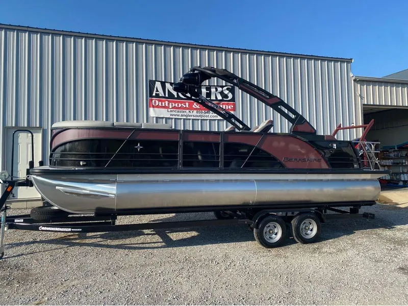 Slide: The Image of 2025 Berkshire 23UL STS pontoon boat on trailer outside Angler's Outpost & Marine. - 1