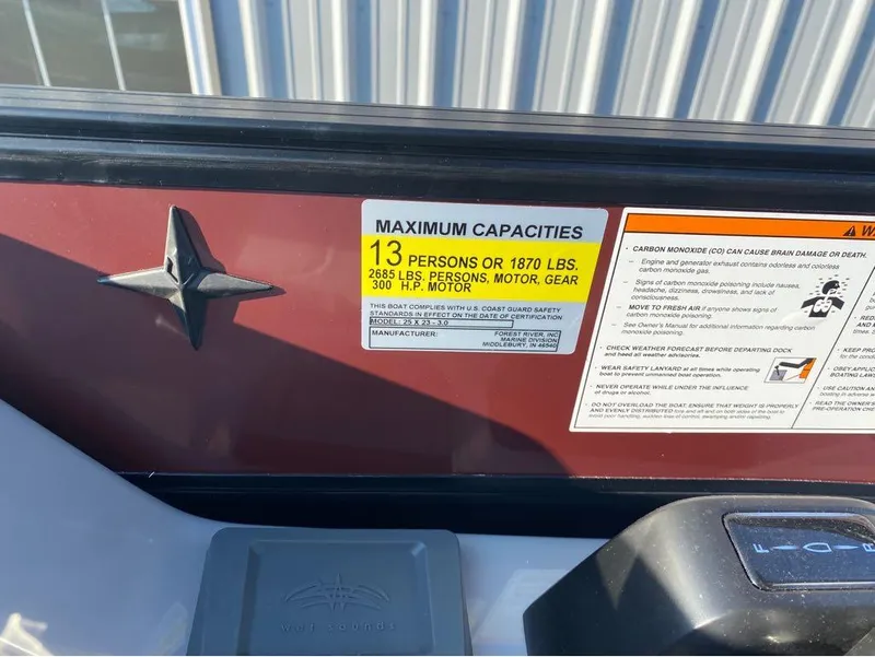 Slide: The Image of Capacity label on 2025 Berkshire 23UL STS boat, showing maximum persons and weight limits. - 12