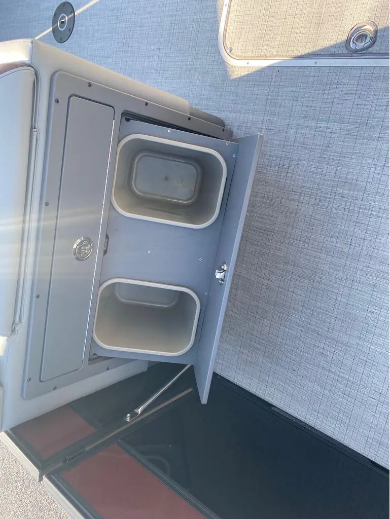 Slide: The Image of 2025 Berkshire 23UL STS boat storage compartment with open bins on deck. - 17