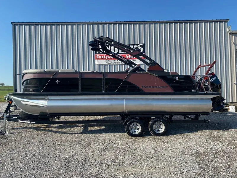 Slide: The Image of 2025 Berkshire 23UL STS pontoon boat on trailer, parked outdoors. - 5