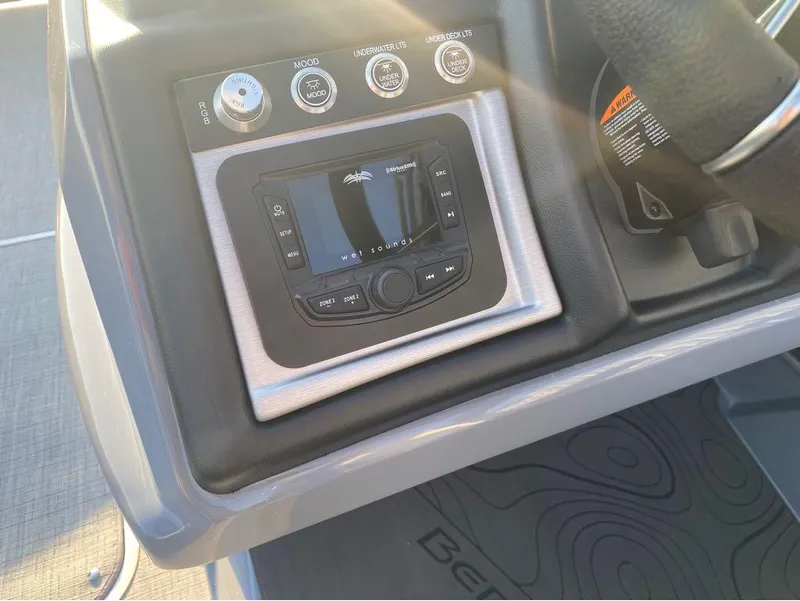Slide: The Image of Control panel of 2025 Berkshire 25RFX STS boat with audio system and lighting controls. - 11