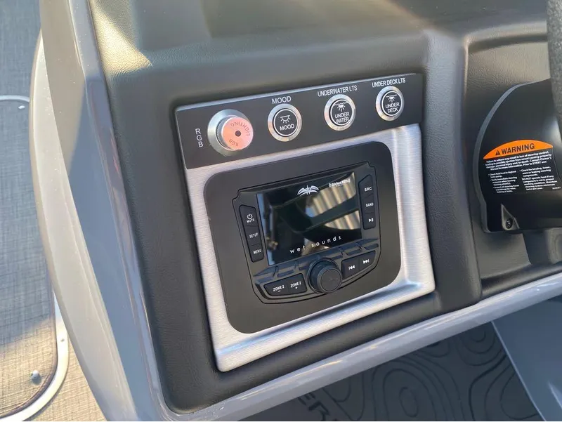 Slide: The Image of Control panel of 2025 Berkshire 25RFX STS boat with audio system and lighting controls. - 12