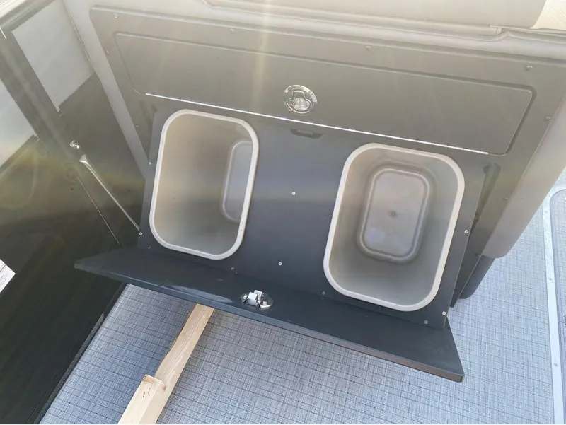 Slide: The Image of Storage compartment with bins in a 2025 Berkshire 25RFX STS boat. - 20
