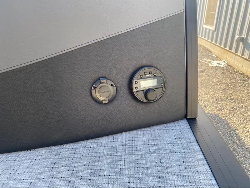 Slide: The Image of 2025 Berkshire 25RFX STS boat control panel with stereo system and power outlet. - 23