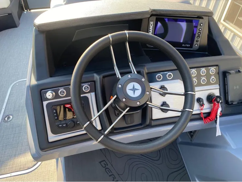 Slide: The Image of Steering wheel and dashboard of 2025 Berkshire 25RFX STS boat with control panel and display. - 5