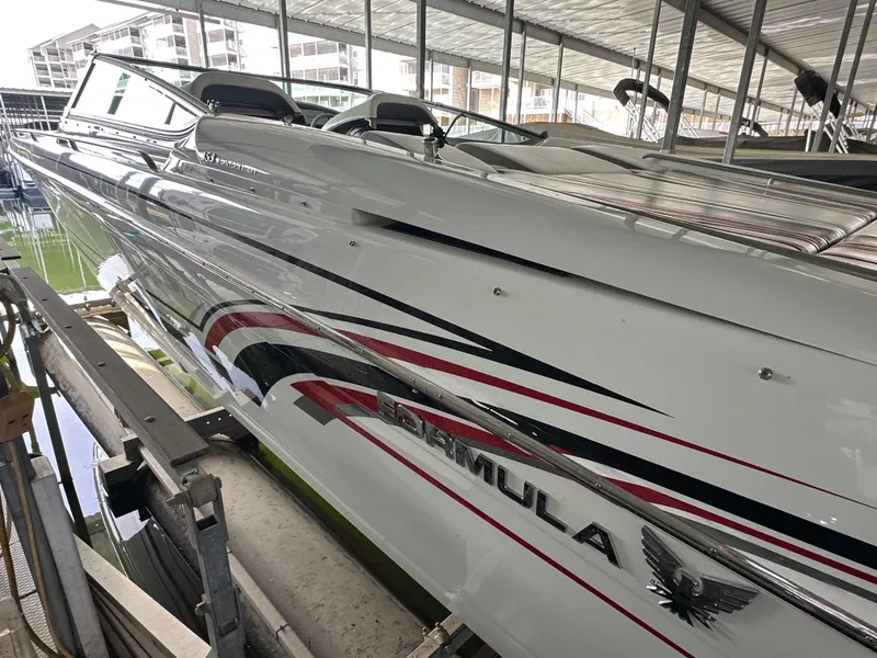 Slide: The Image of 2008 Formula 353 FASTech boat docked in marina, sleek design with red and black accents. - 19