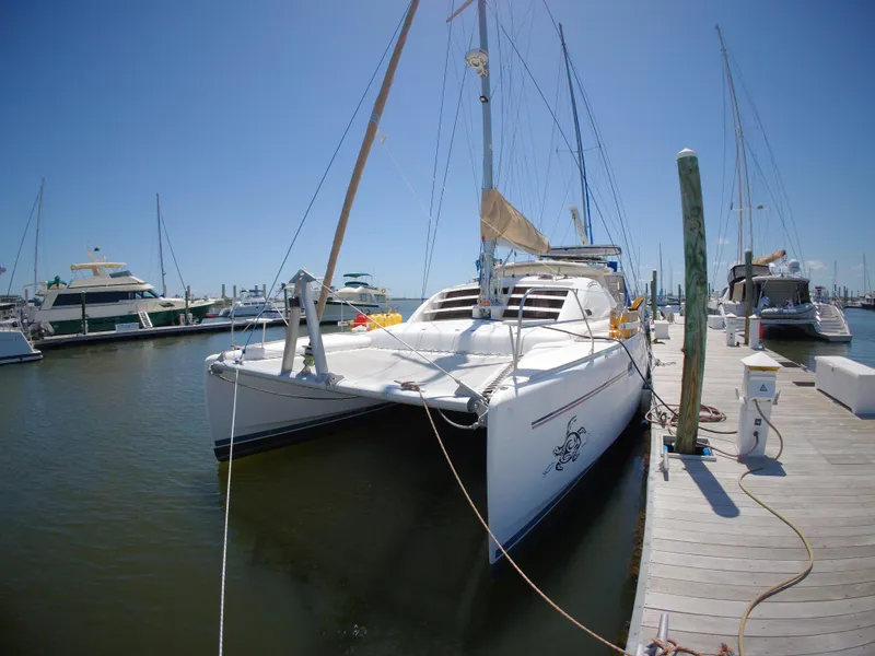 The Image of 2005 Leopard 40 catamaran docked at marina under clear blue sky. - 0