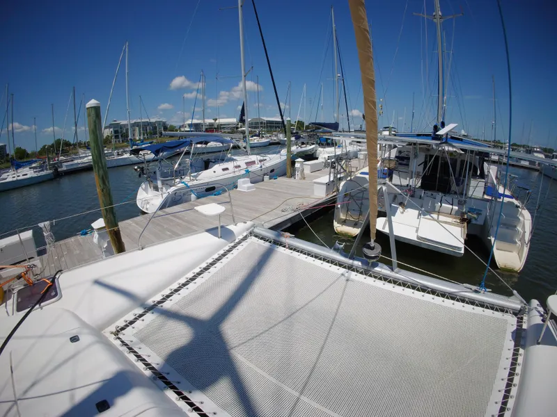 Slide: The Image of 2005 Leopard 40 catamaran docked at a marina with other sailboats under a clear blue sky. - 18