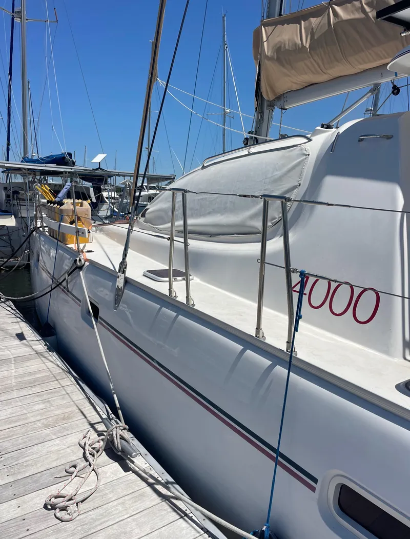 Slide: The Image of 2005 Leopard 40 catamaran docked at marina under clear blue sky. - 21