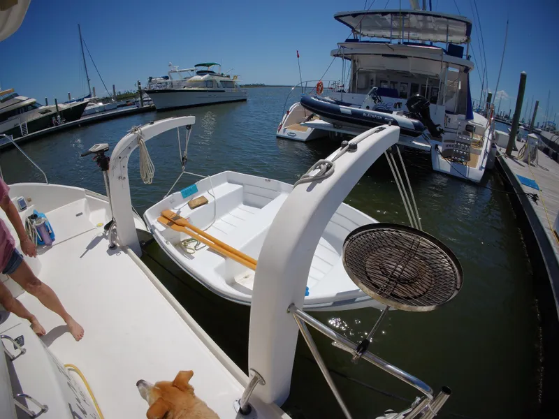 Slide: The Image of Docked Leopard 40 catamaran with dinghy and dog, 2005 model, in a sunny marina. - 22