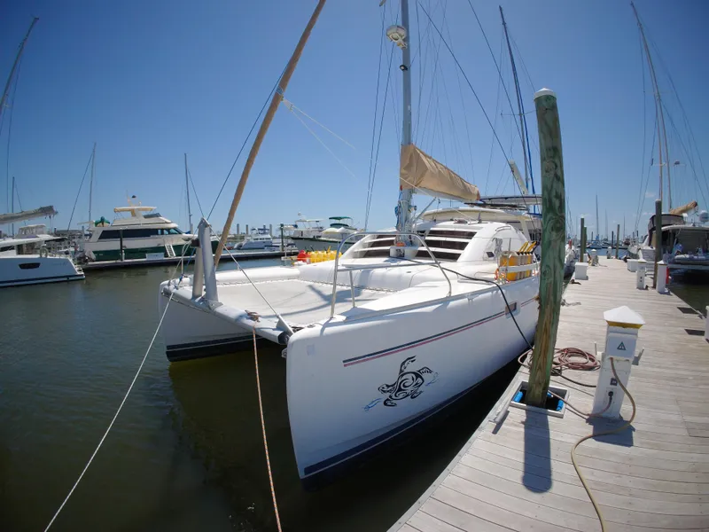 Slide: The Image of 2005 Leopard 40 catamaran docked at marina under clear blue sky. - 3