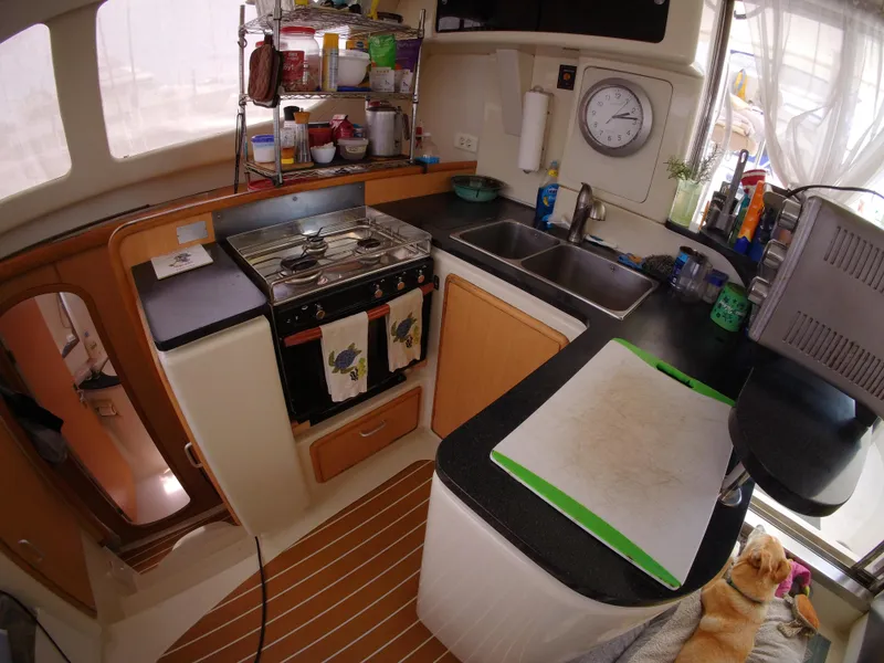 Slide: The Image of Compact kitchen in a 2005 Leopard 40 catamaran with stove, sink, and storage. - 32