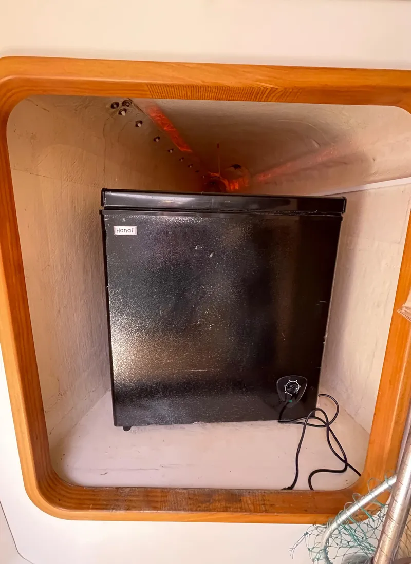 Slide: The Image of Small black refrigerator inside a wooden-framed compartment on a 2005 Leopard 40. - 37