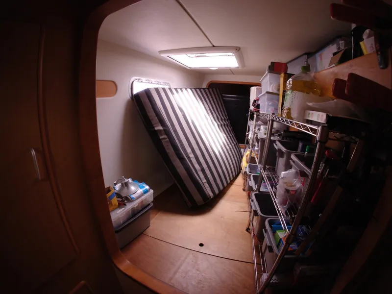 Slide: The Image of Interior of a 2005 Leopard 40 boat with storage shelves and a striped mattress. - 38