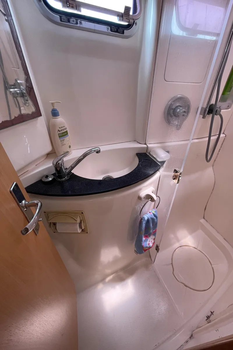 Slide: The Image of Compact bathroom in a 2005 Leopard 40 yacht, featuring a sink and shower area. - 44