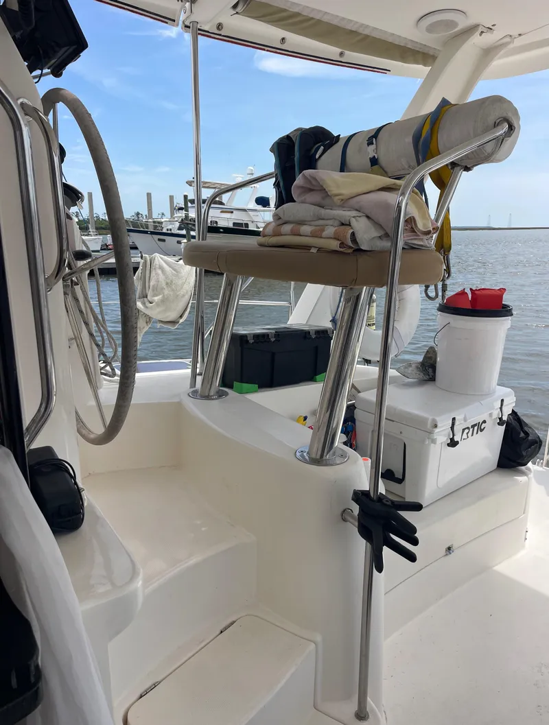 Slide: The Image of 2005 Leopard 40 yacht cockpit with steering wheel and seating, docked by the water. - 8