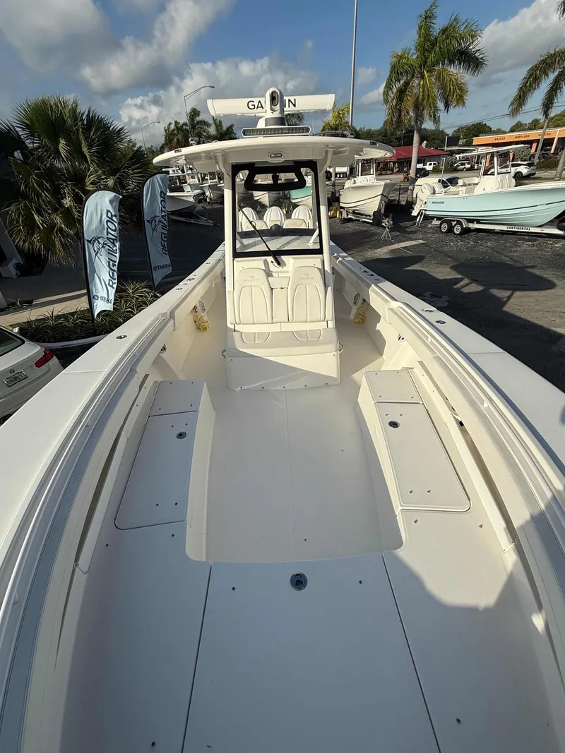 Slide: The Image of 2023 Regulator 34 boat, spacious deck, palm trees, and clear sky in the background. - 10