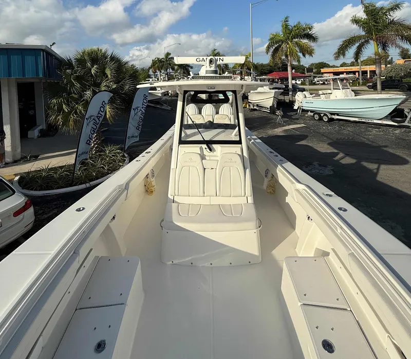 Slide: The Image of 2023 Regulator 34 boat at a marina, showcasing spacious deck and seating. - 11