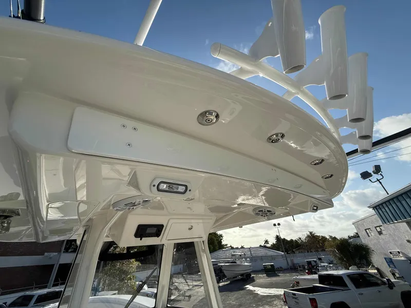Slide: The Image of 2023 Regulator 34 boat, featuring sleek design and rod holders, under a clear blue sky. - 14