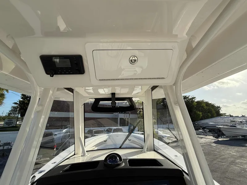 Slide: The Image of 2023 Regulator 34 boat interior, featuring helm station and overhead storage compartment. - 18