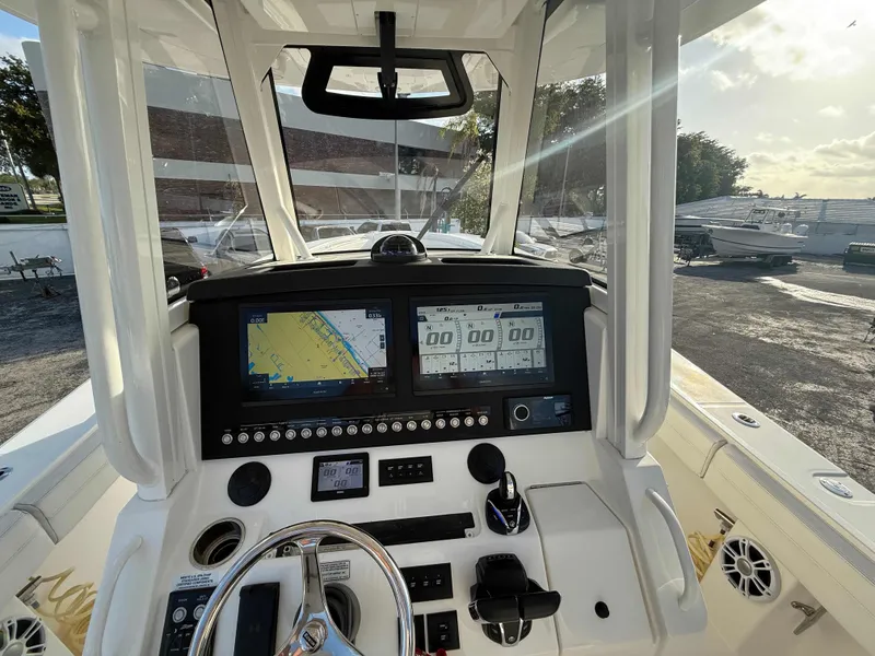 Slide: The Image of 2023 Regulator 34 boat dashboard with navigation screens and controls in a marina setting. - 19