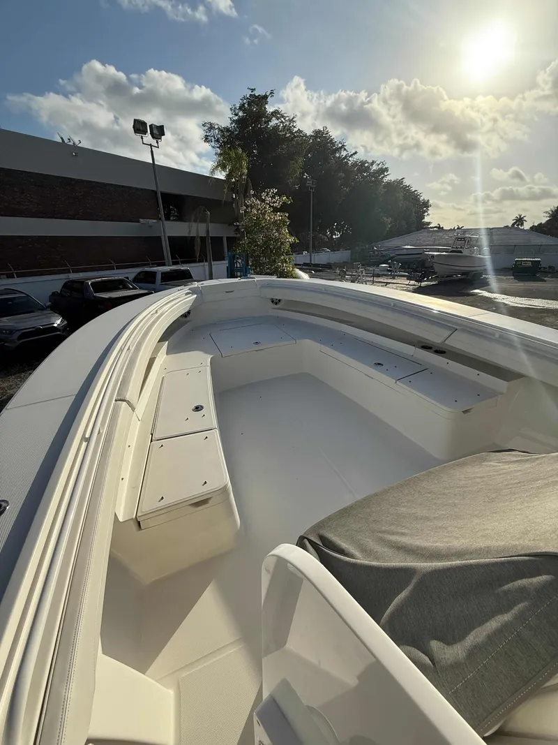 Slide: The Image of 2023 Regulator 34 boat deck under sunny sky, parked near building. - 21