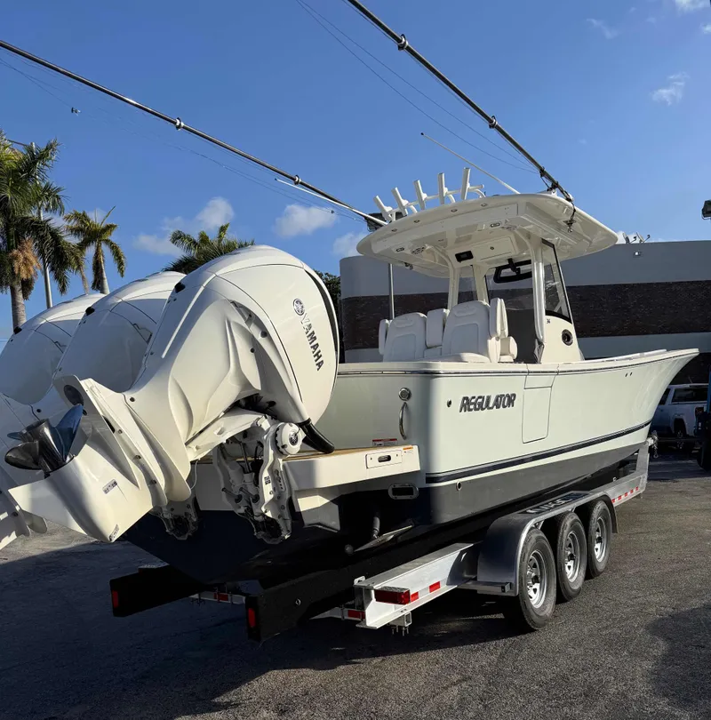 Slide: The Image of 2023 Regulator 34 boat with Yamaha engines on a trailer, parked outdoors. - 31