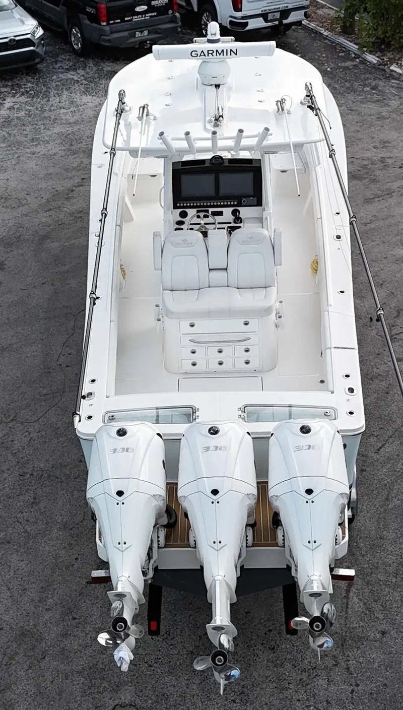 Slide: The Image of 2023 Regulator 34 boat with triple engines, aerial view, parked on gravel. - 36