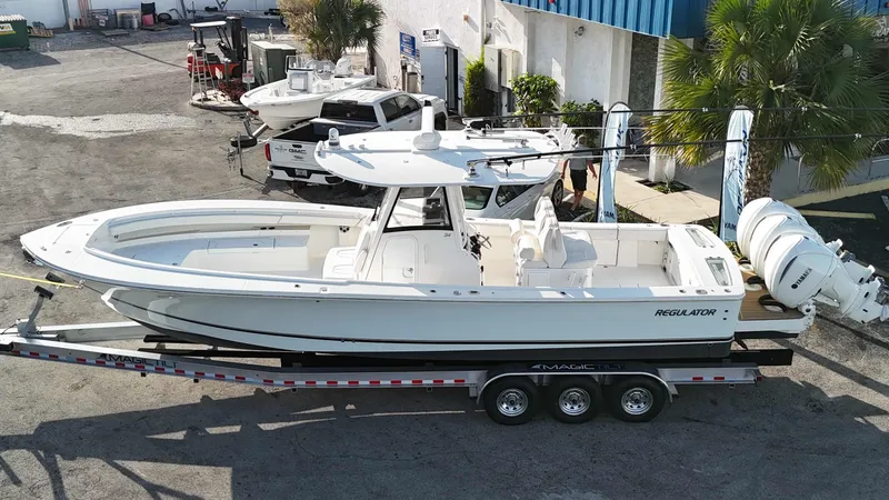 Slide: The Image of 2023 Regulator 34 boat on trailer, parked outdoors near a building. - 40