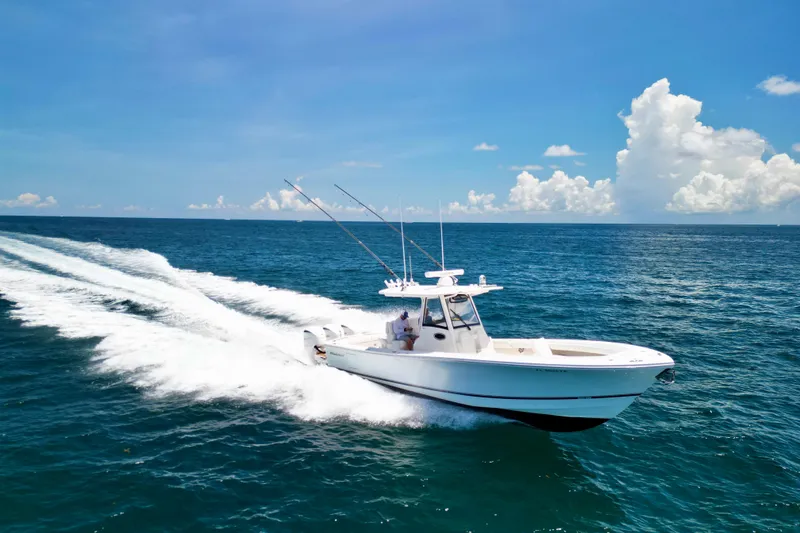 Slide: The Image of 2023 Regulator 34 boat cruising on open ocean under clear blue sky. - 45