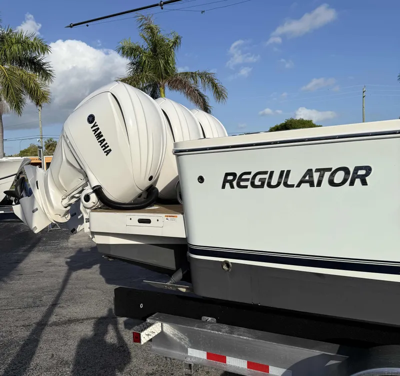Slide: The Image of 2023 Regulator 34 boat with Yamaha engines, parked under palm trees. - 5