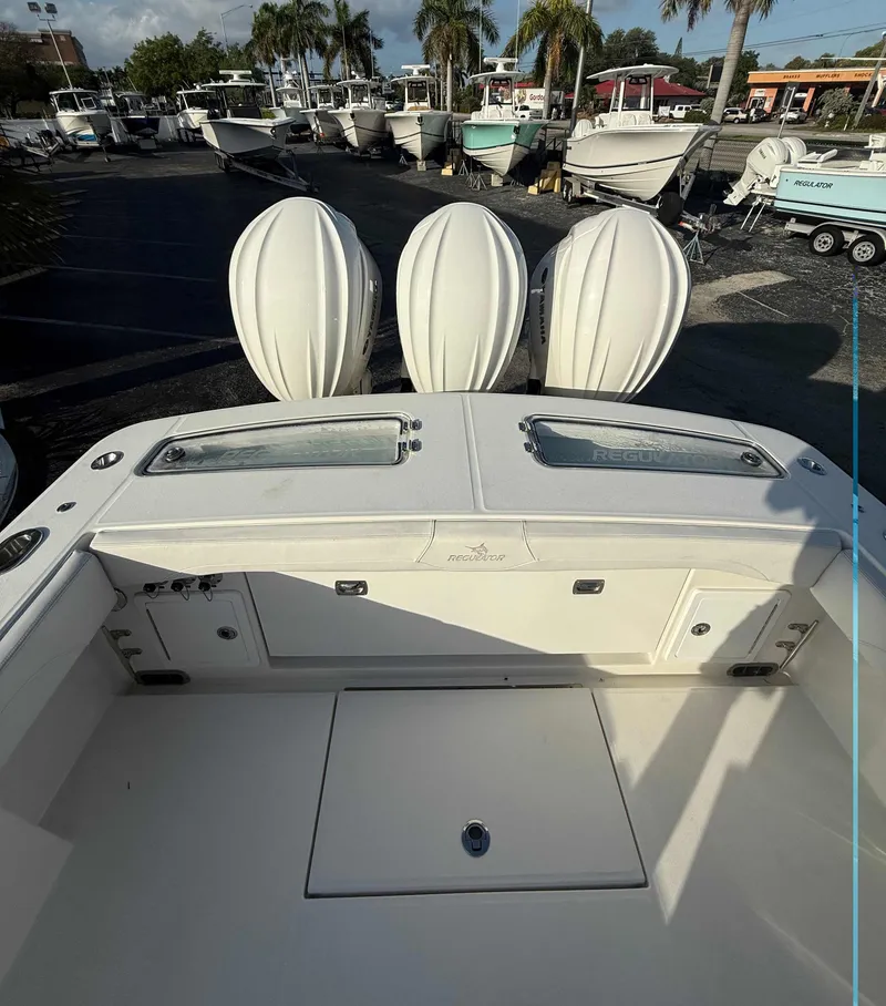Slide: The Image of 2023 Regulator 34 boat with triple engines, docked in a marina. - 7