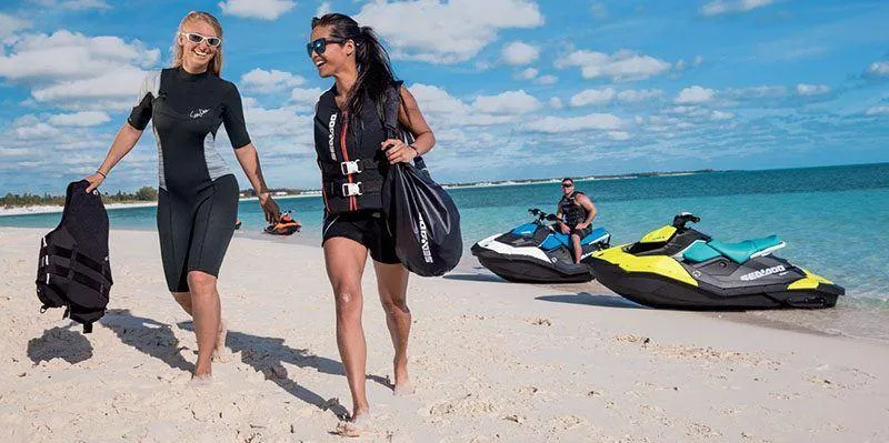 Slide: The Image of Two people walking on a beach with Sea-Doo Spark jet skis in the background. - 11