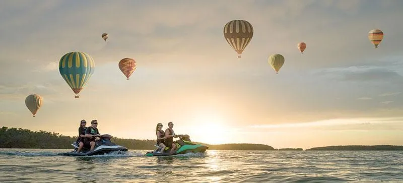 Slide: The Image of 2019 Sea-Doo Spark 2up jet skis on water with hot air balloons at sunset. - 13