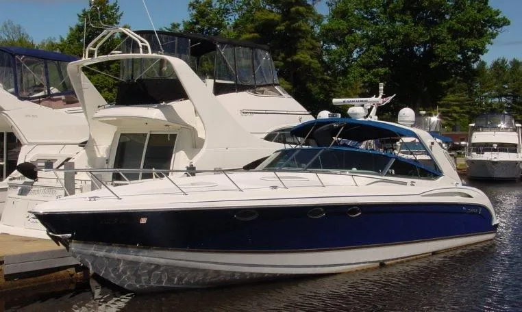 Slide: The Image of 2002 Formula 400 SS boat docked at marina, surrounded by other yachts and trees. - 14