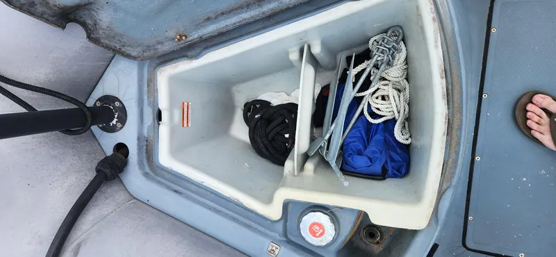 Slide: The Image of Open storage compartment on a 2011 Zodiac Milpro 2100 LE boat with ropes and gear. - 10