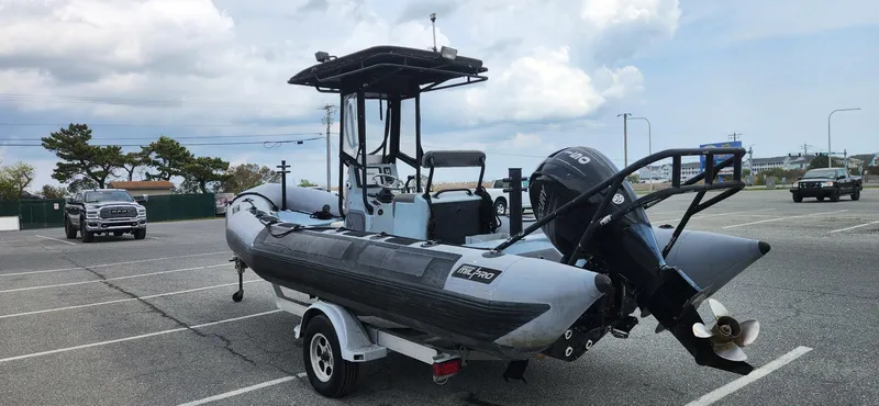 Slide: The Image of 2011 Zodiac Milpro 2100 LE boat on trailer in parking lot, cloudy sky background. - 5