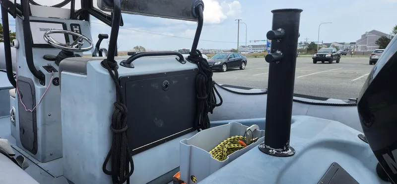 Slide: The Image of Interior view of a 2011 Zodiac Milpro 2100 LE boat, showcasing control panel and storage area. - 9