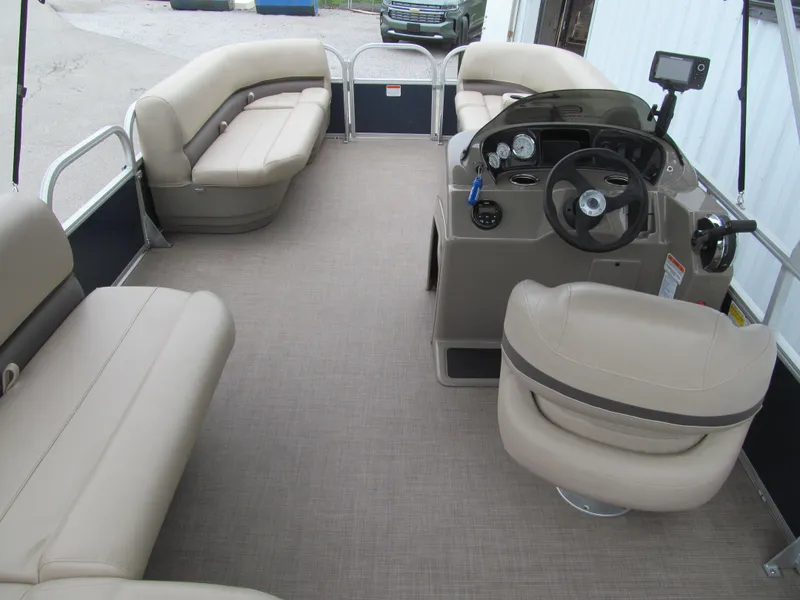 Slide: The Image of 2020 Sun Tracker Party Barge 18 DLX interior with beige seating and steering console. - 4